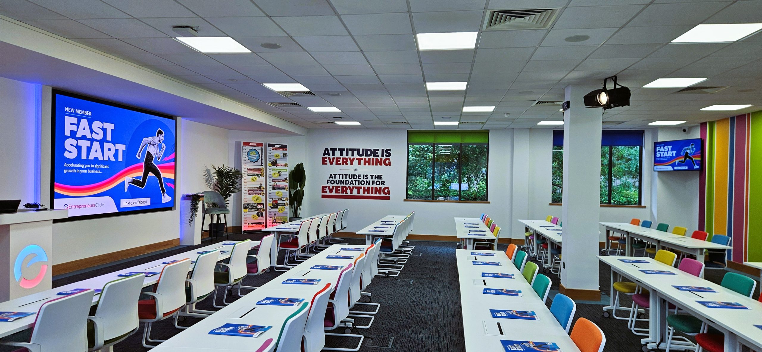 Training room set up for live session at Entrepreneurs Circle with large AV display and repeater screen